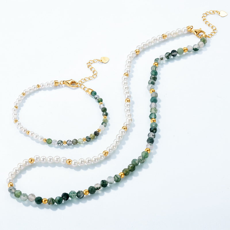 Gold - toned beaded jewelry set: Bracelet and necklace, both with white pearls, green stones, gold spacers, white background.