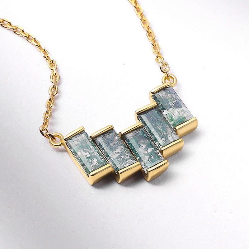 Gold - toned necklace: Geometric pendant with rectangular moss agate stones, isolated on white with soft shadows.