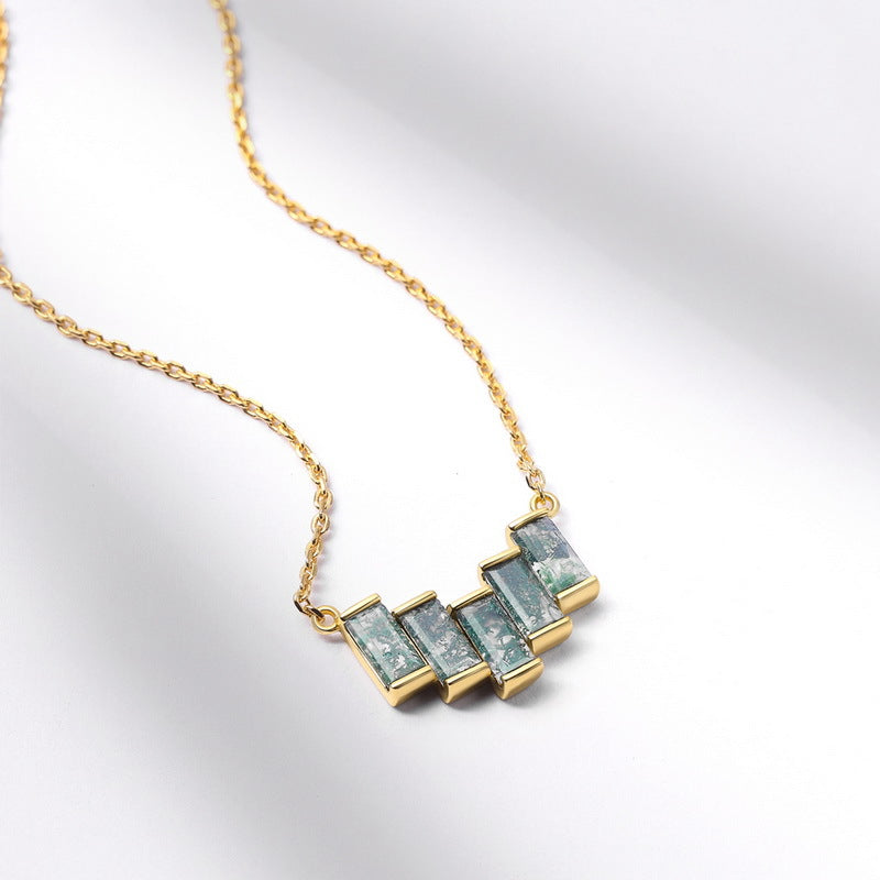 Gold - toned necklace: Geometric pendant with rectangular moss agate stones, isolated on white with soft shadows.