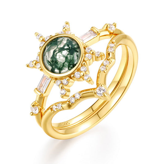 Gold - toned ring set: A sun - designed moss agate ring combined with a curved crystal - decorated ring, isolated on a white background.