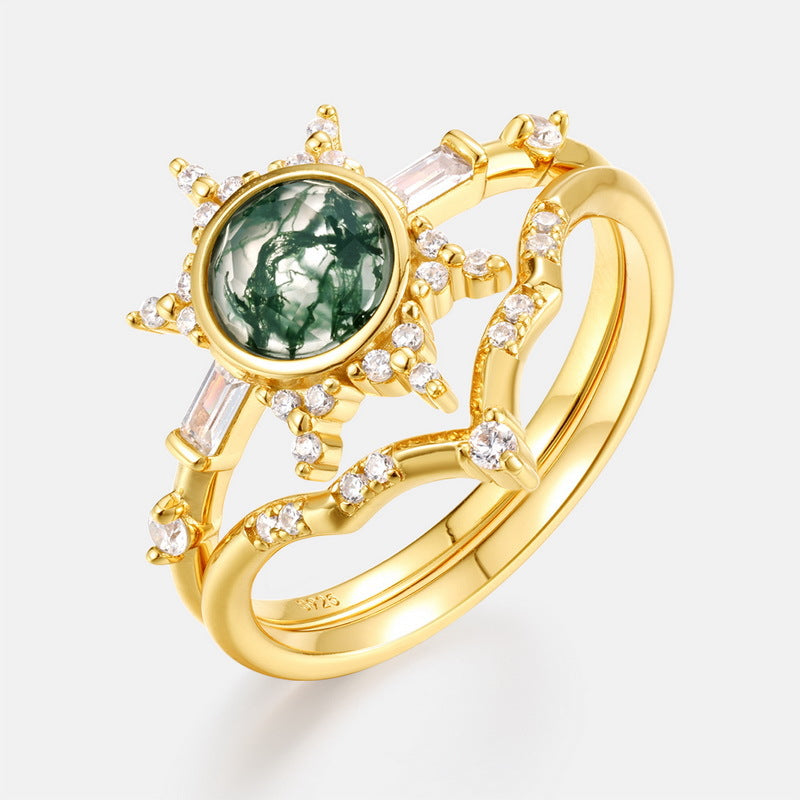 Gold - toned ring set: A sun - designed moss agate ring combined with a curved crystal - decorated ring, isolated on a white background.