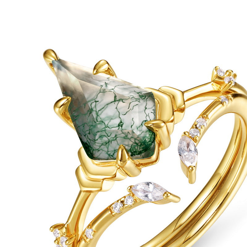 Close - up of gold ring: Teardrop moss agate, crystal - studded branches, isolated on a white background.