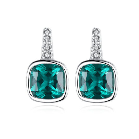 Pair of earrings with green gemstones on a white background