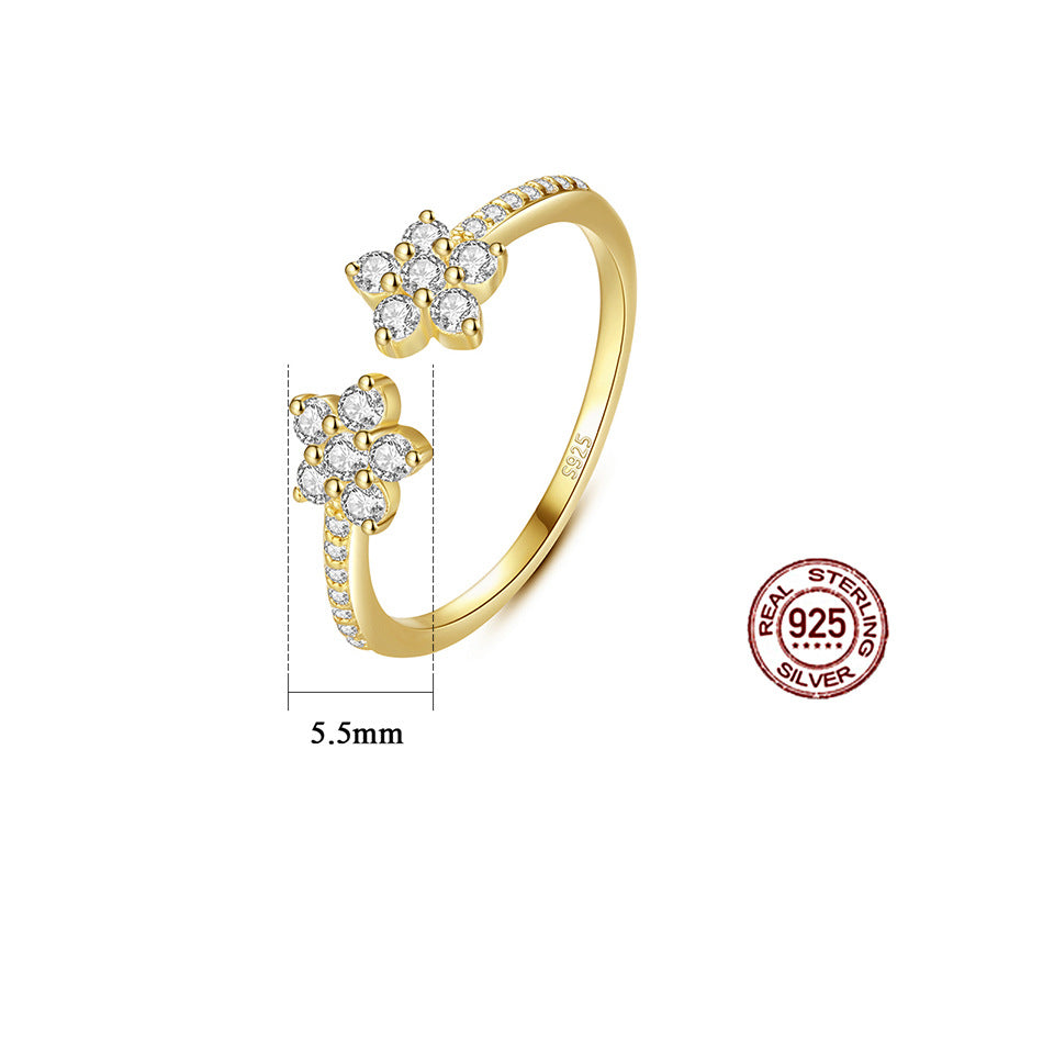 Gold ring with floral designs and 'Real Sterling Silver' stamp on a white background