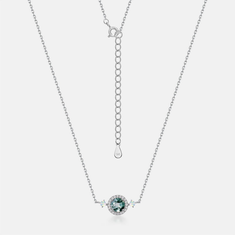 Silver - toned necklace: Circular moss agate pendant, crystal halo, opal - like accents, adjustable chain with teardrop tag, isolated on white.
