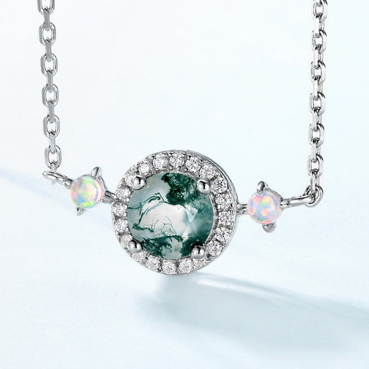 Extreme close - up of silver - toned necklace pendant: Circular moss agate stone, crystal halo, opal - like accents, isolated on white, emphasizing intricate details.