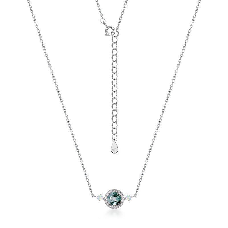 Silver - toned necklace: Circular moss agate pendant, crystal halo, opal - like accents, adjustable chain with teardrop tag, isolated on gray.