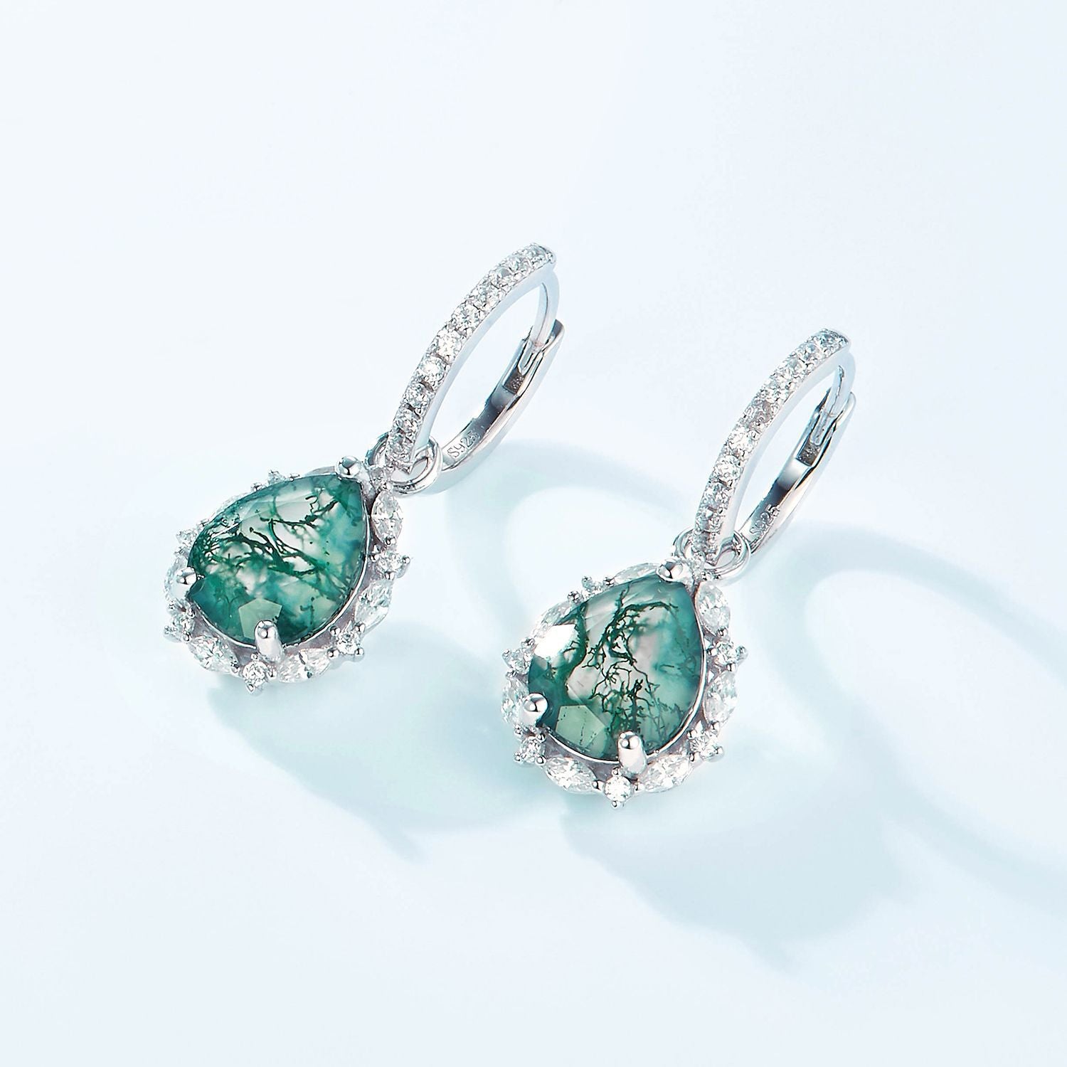 Silver - toned earrings: Teardrop moss agate, crystal halo, hoop design, isolated on white.