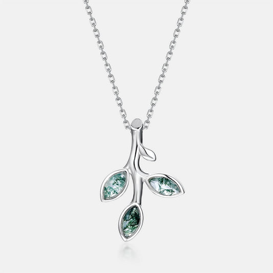 Silver - toned necklace: Branch - shaped pendant, three leaf - like settings with green moss agate, isolated on gray.