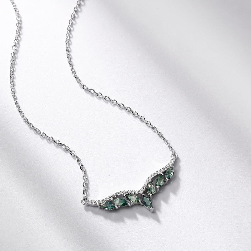 Silver - toned necklace: V - shaped pendant with marquise moss agate stones, crystal accents, isolated on white with soft shadows.