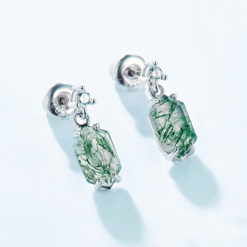 Silver earrings with moss agate dangles, cubic zirconia accents, shown from back view on light blue