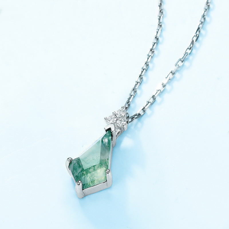 Silver necklace with irregular - shaped moss agate pendant, cubic zirconia accents, on light blue background