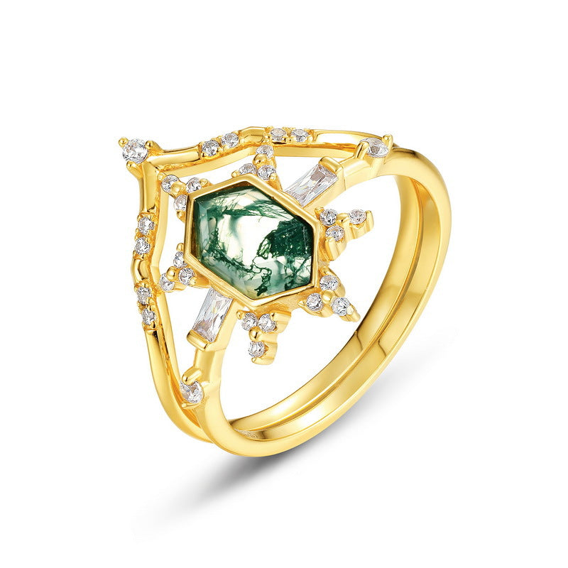 Gold - toned ring set: Hexagonal moss agate ring with crystal - decorated bands, isolated on white.