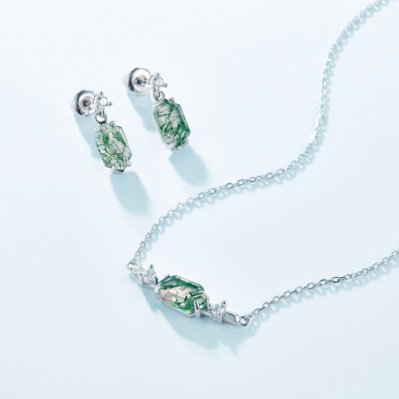 Silver jewelry set: Moss agate earrings and necklace, cubic zirconia details, displayed on light blue