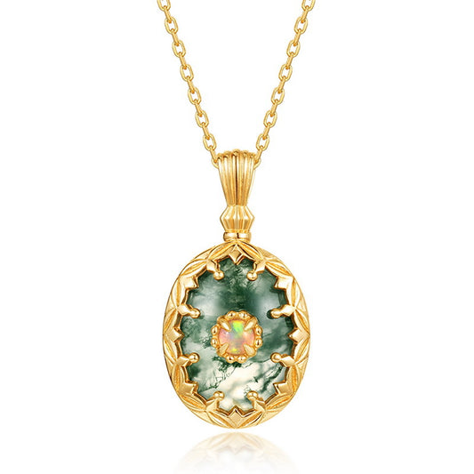 Gold - toned necklace: Oval moss agate pendant with central opal, decorative frame, isolated on white.