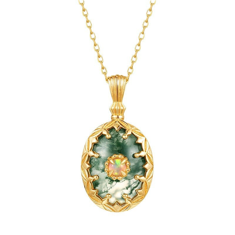 Gold pendant necklace with a green stone on a white background