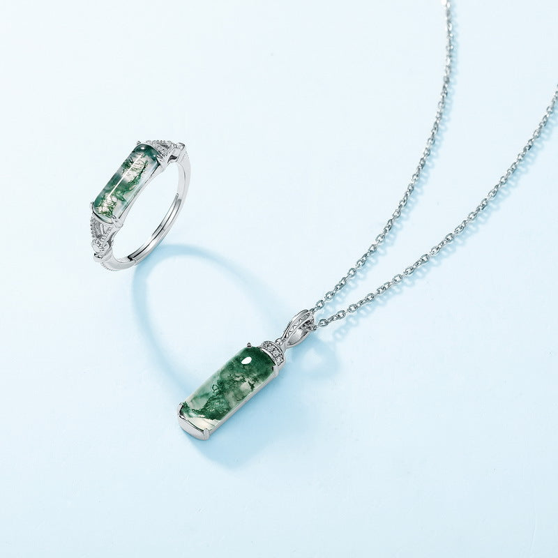 Silver jewelry set: Moss agate ring and necklace, cubic zirconia accents, displayed on light blue