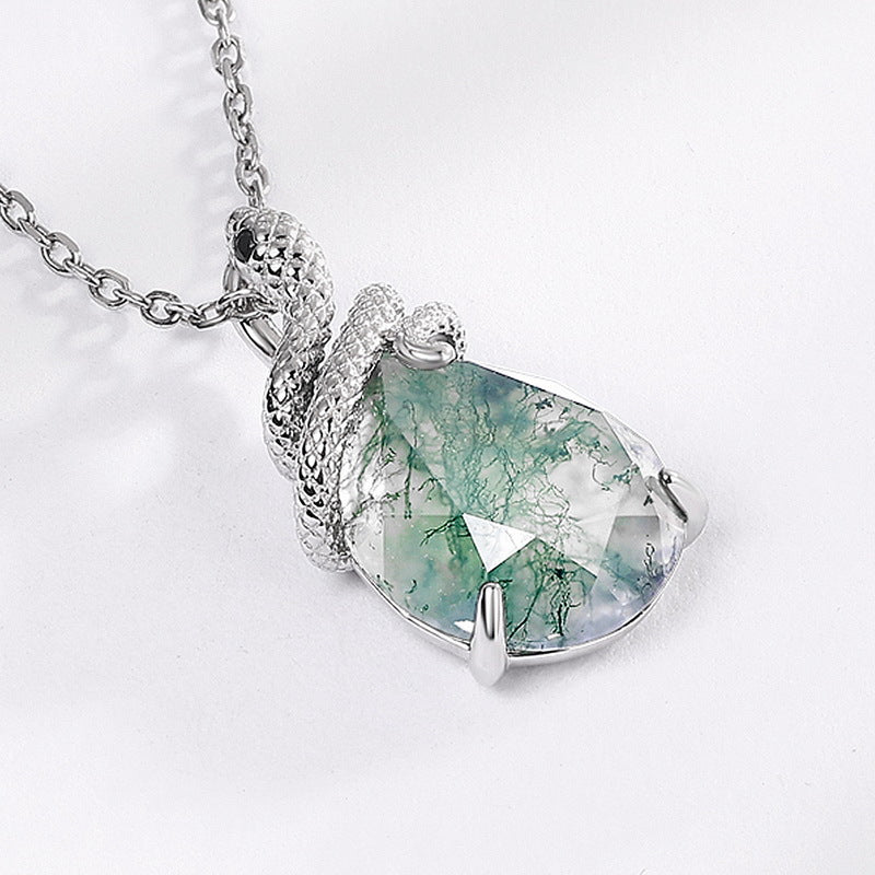 Silver - chained necklace with teardrop moss agate pendant wrapped by snake - shaped metal, worn on a person's neck, elegant daily accessory