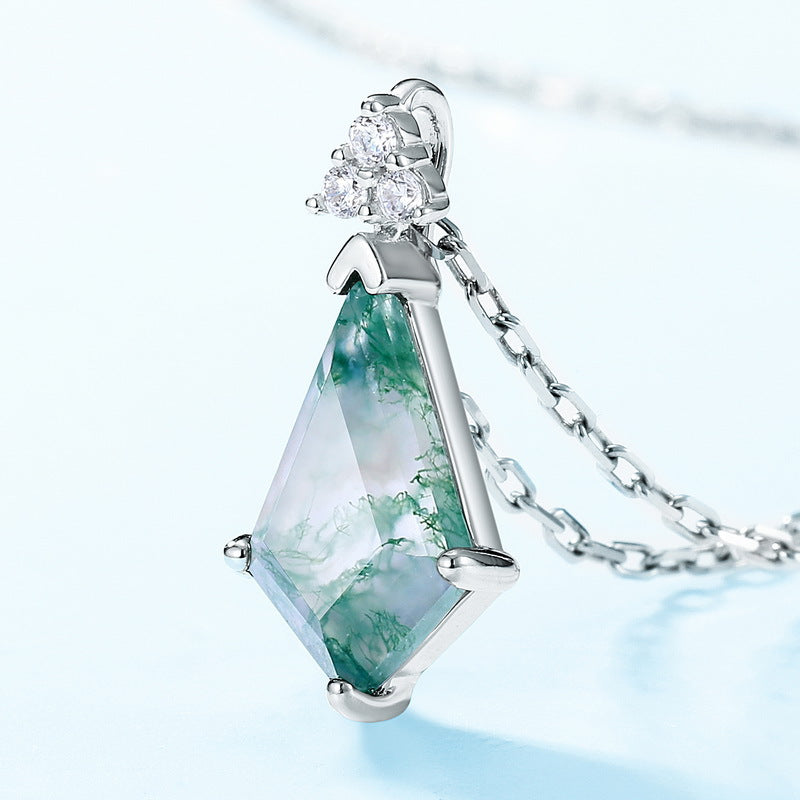 Silver necklace with moss agate pendant, cubic zirconia trio accents, close - up on light blue background