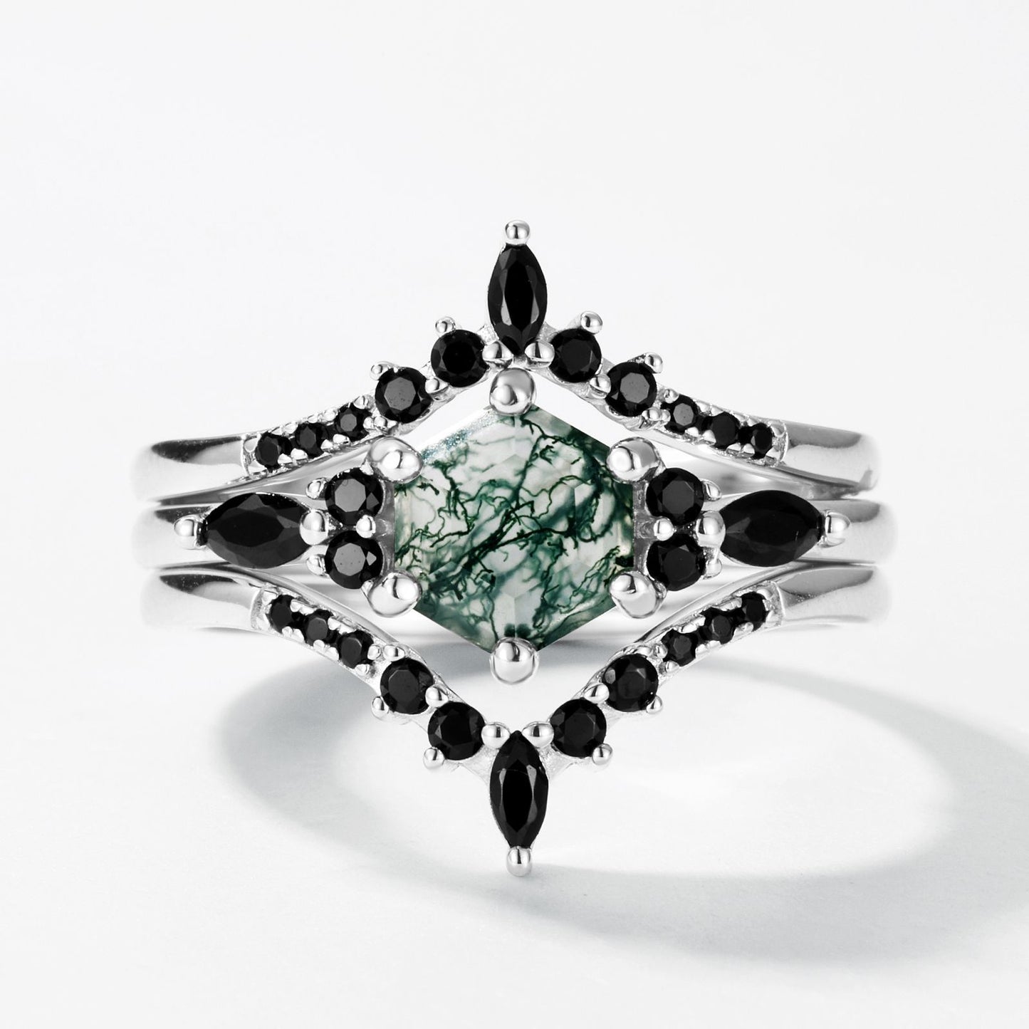 Silver - toned ring set: Hexagonal moss agate ring with black gemstone - encrusted bands, isolated on white.
