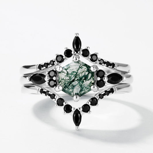 Silver - toned ring set: Hexagonal moss agate ring with black gemstone - encrusted bands, isolated on white.
