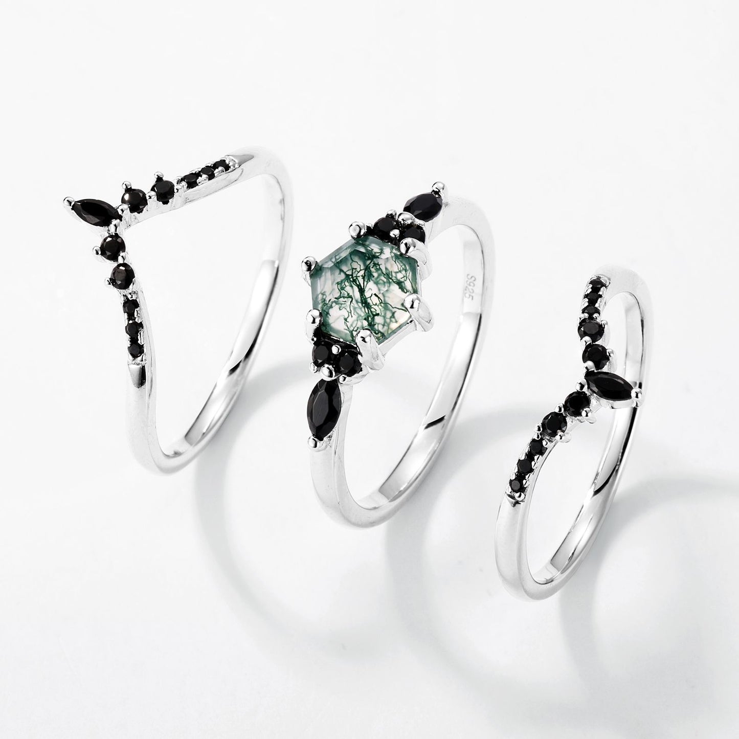 Silver - toned ring set: Hexagonal moss agate ring with multi - layer black gemstone - decorated bands, isolated on white.