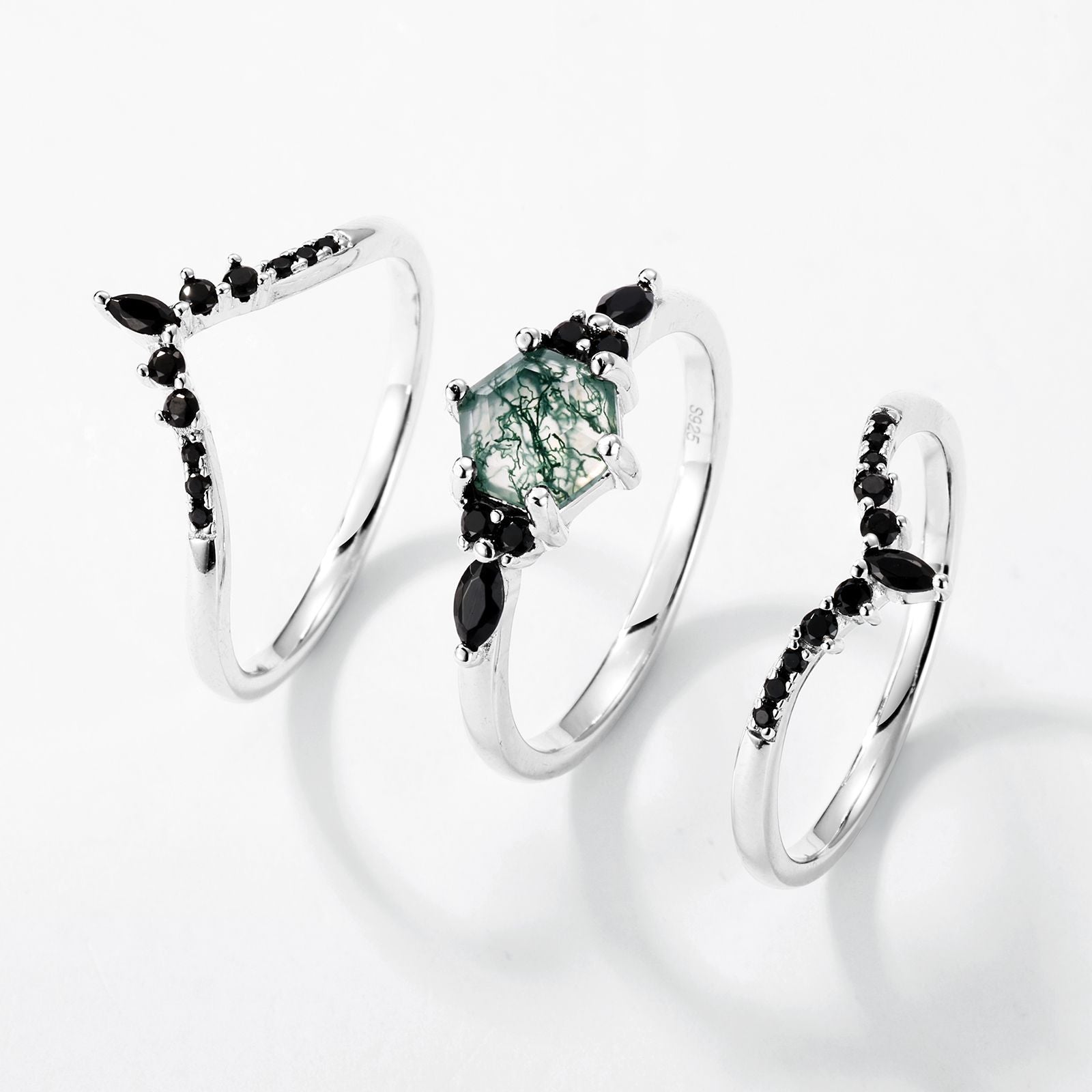 Silver - toned ring set: Hexagonal moss agate ring with multi - layer black gemstone - decorated bands, isolated on white.