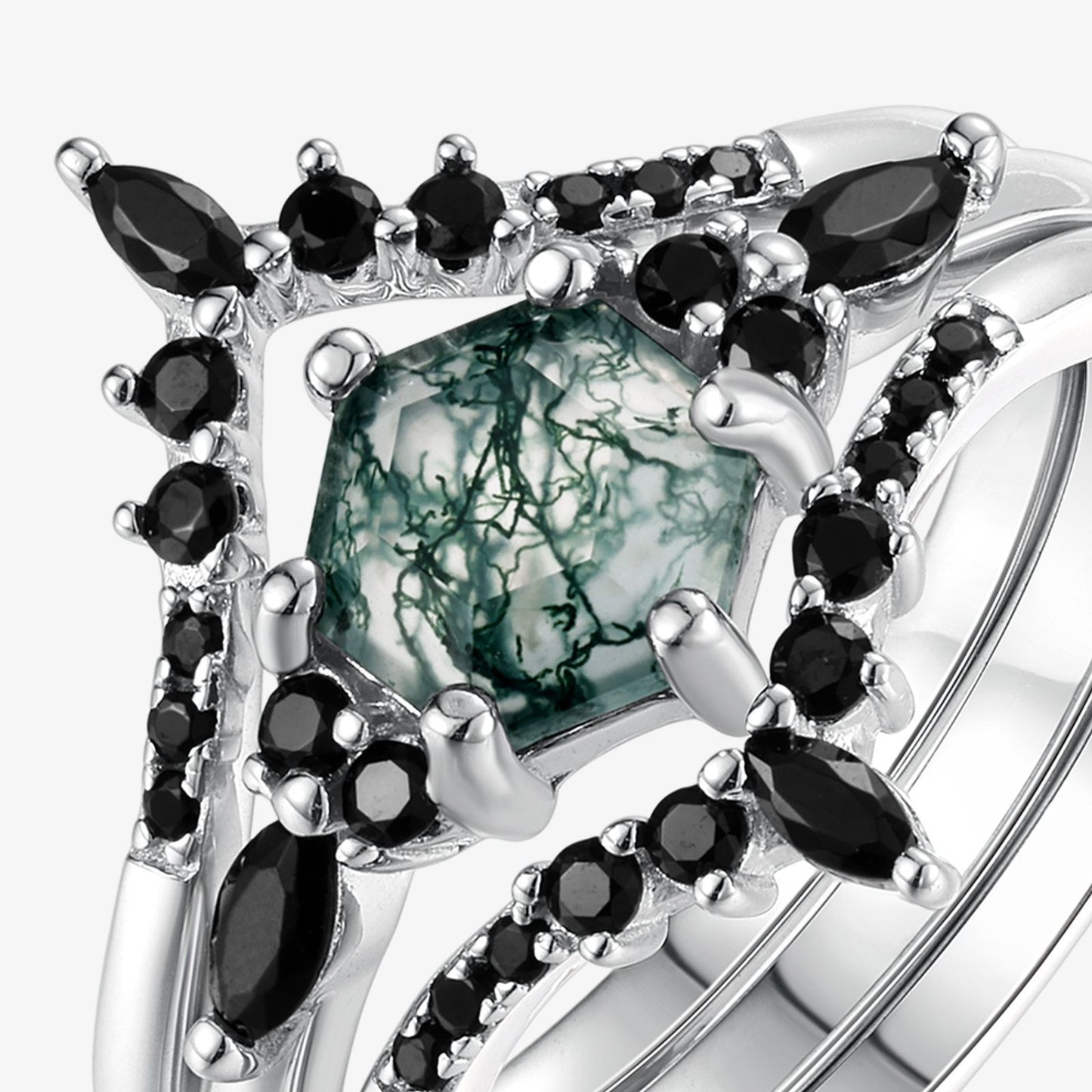 Extreme close - up of silver - toned ring set: Highlights the intricate patterns in the hexagonal moss agate, framed by black gemstones, isolated on white.