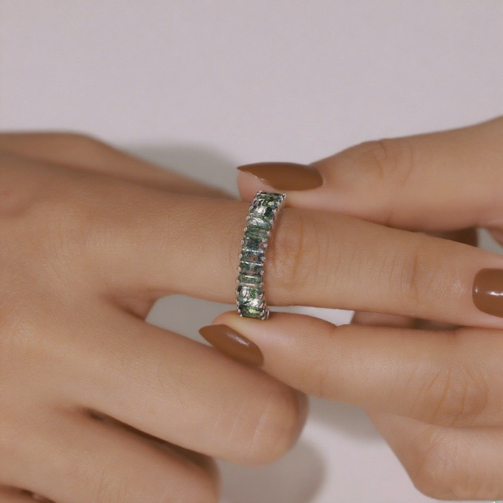 Silver ring with moss agate, worn on a hand with brown nails, demonstrating a stylish choice for daily accessorizing.