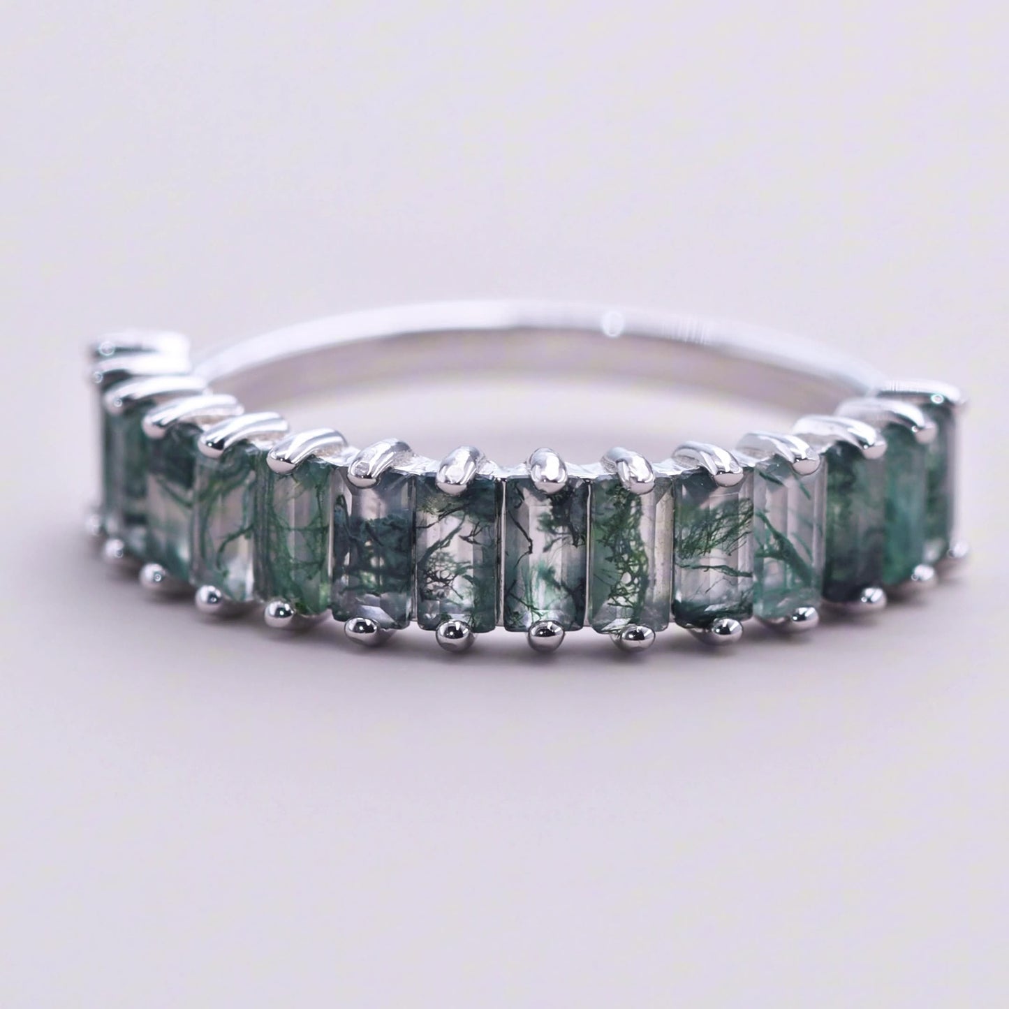 Silver ring: A row of rectangular moss agate settings, isolated on a light gray background, highlighting the unique stone patterns.