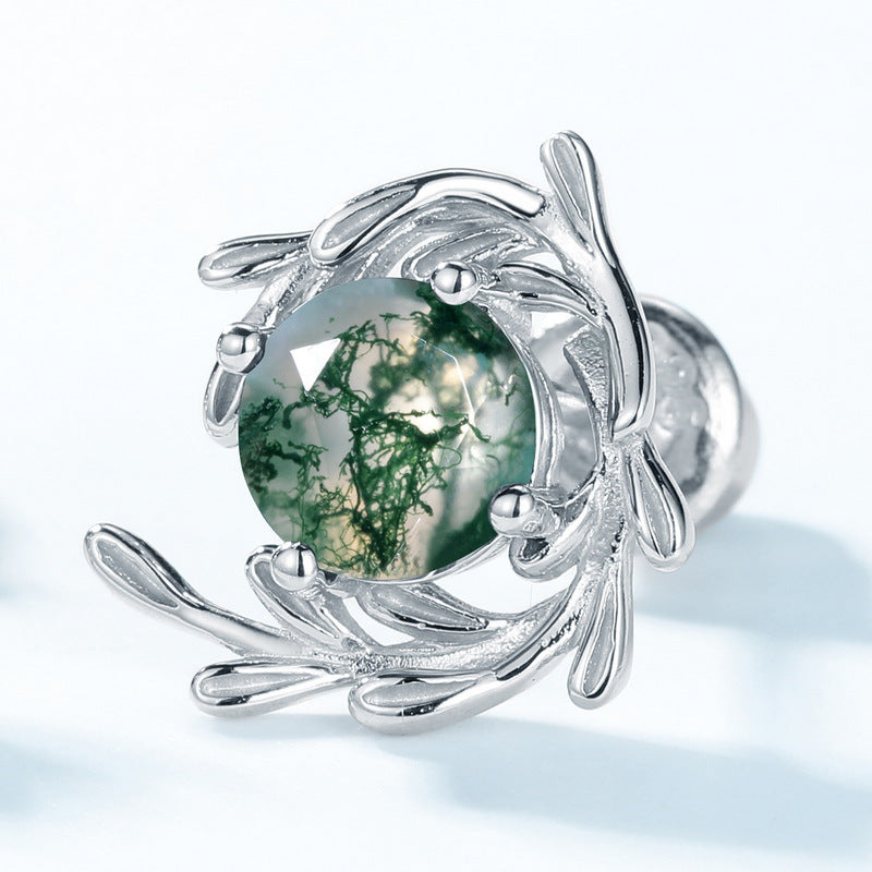 Extreme close - up of silver - toned earring: Leafy branch frame, round moss agate stone, isolated on white, emphasizing intricate details.