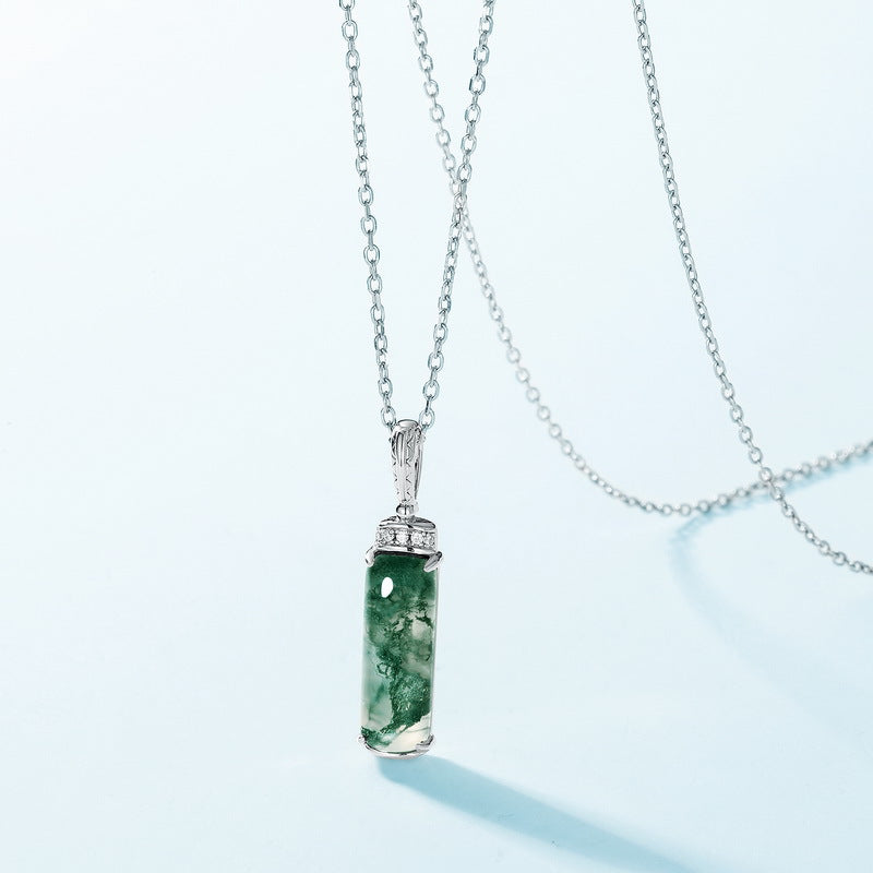 Silver necklace with moss agate pendant, cubic zirconia accents, presented on light blue background