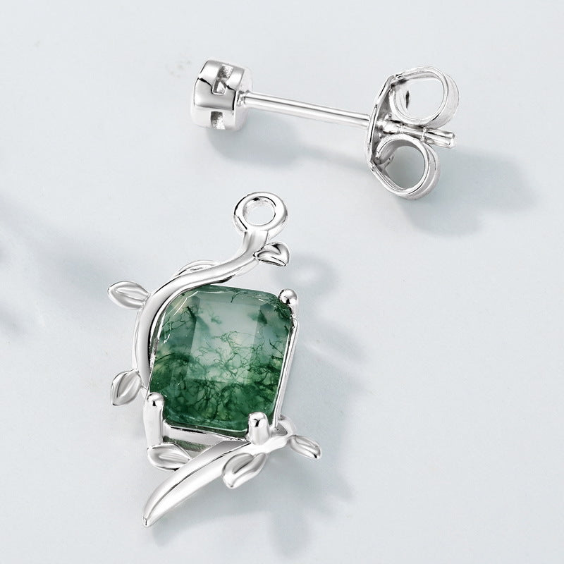 Silver earrings: Moss agate center, leaf - detailed setting, extreme close - up on light gray, showcasing intricate design