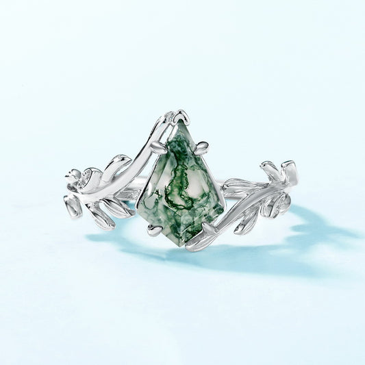 Silver ring: Diamond - shaped moss agate, leaf - branch setting, on light blue.