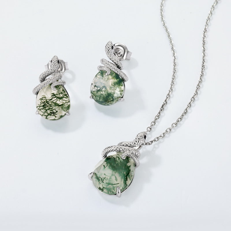 Silver - toned jewelry set: Includes earrings and a necklace, both with snake - wrapped teardrop moss agate designs, isolated on white.