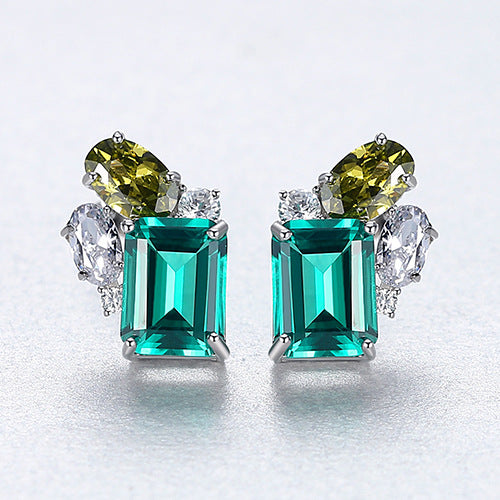 Pair of earrings with emerald-cut gemstones on a light gray background