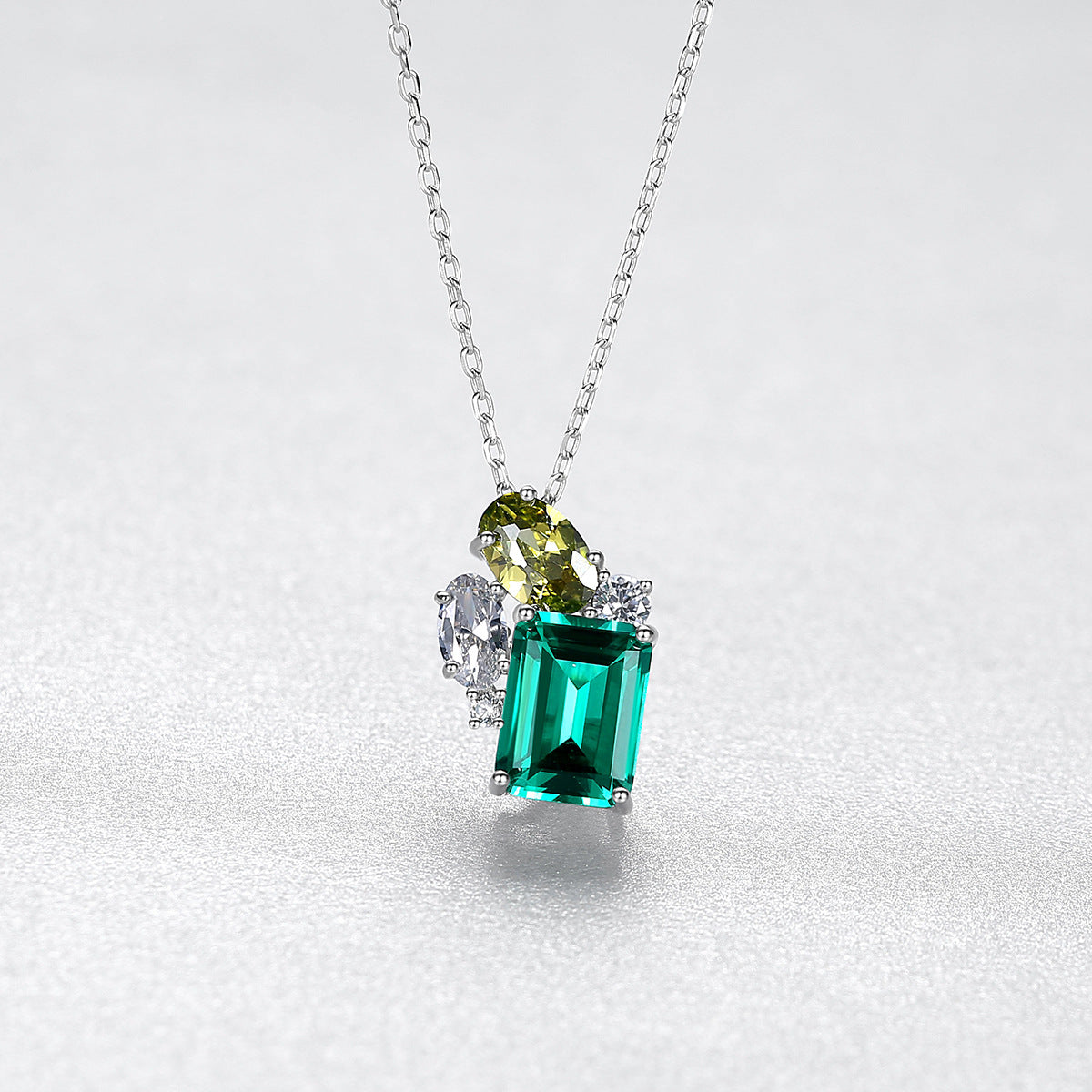 Jewelry necklace with a green gemstone pendant on a white background