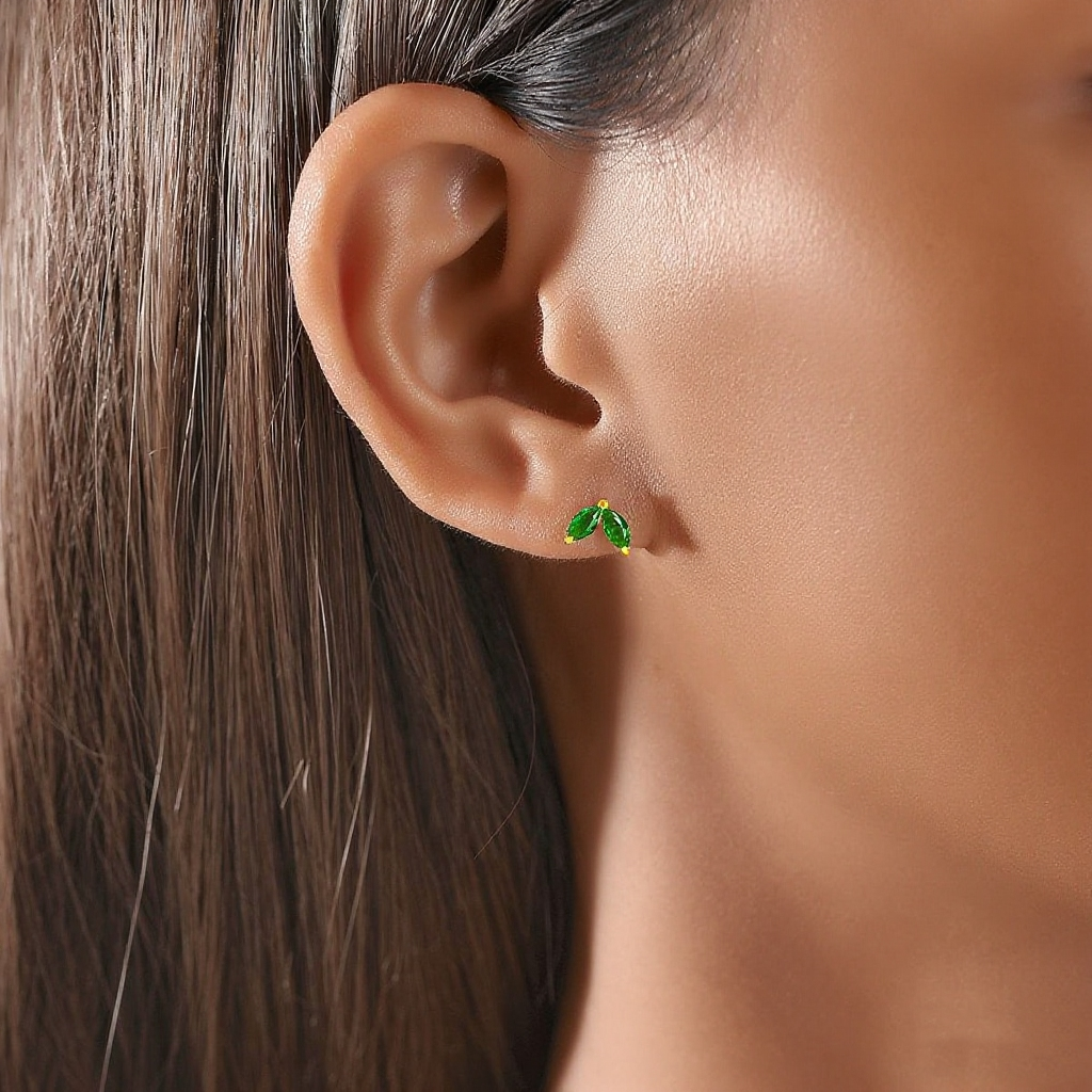 Close-up of an ear wearing a green earring with a blurred background