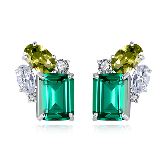Pair of earrings with emerald peridot and cubic zirconia gemstones on a white background
